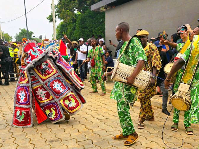 Egungun masquerade dancing to drum beats and chanting supporters, Benin 2026